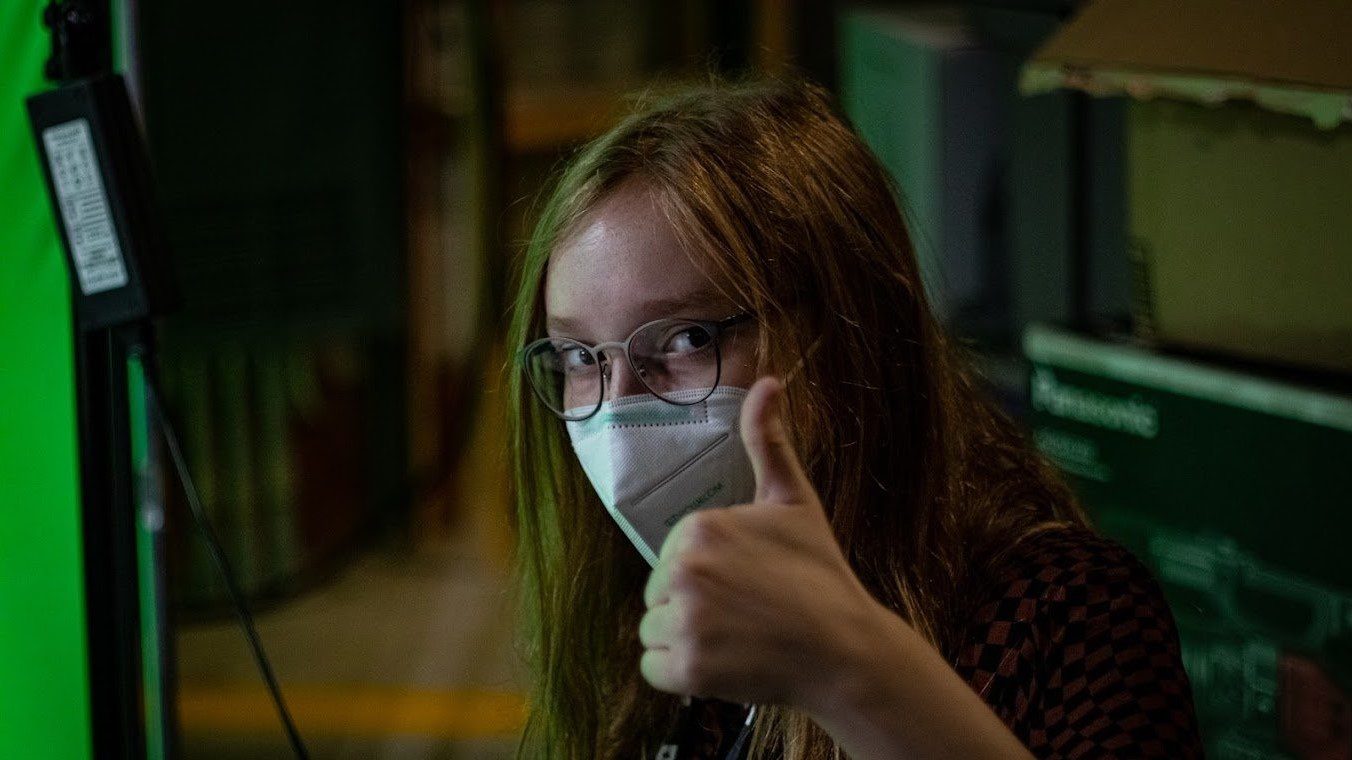 Mimi throws a thumbs up the cameraman.