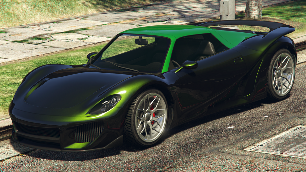 A green Pfister 811 parked beside the curb on a tarmac rode, with grass, a tree, and steetlight behind it.