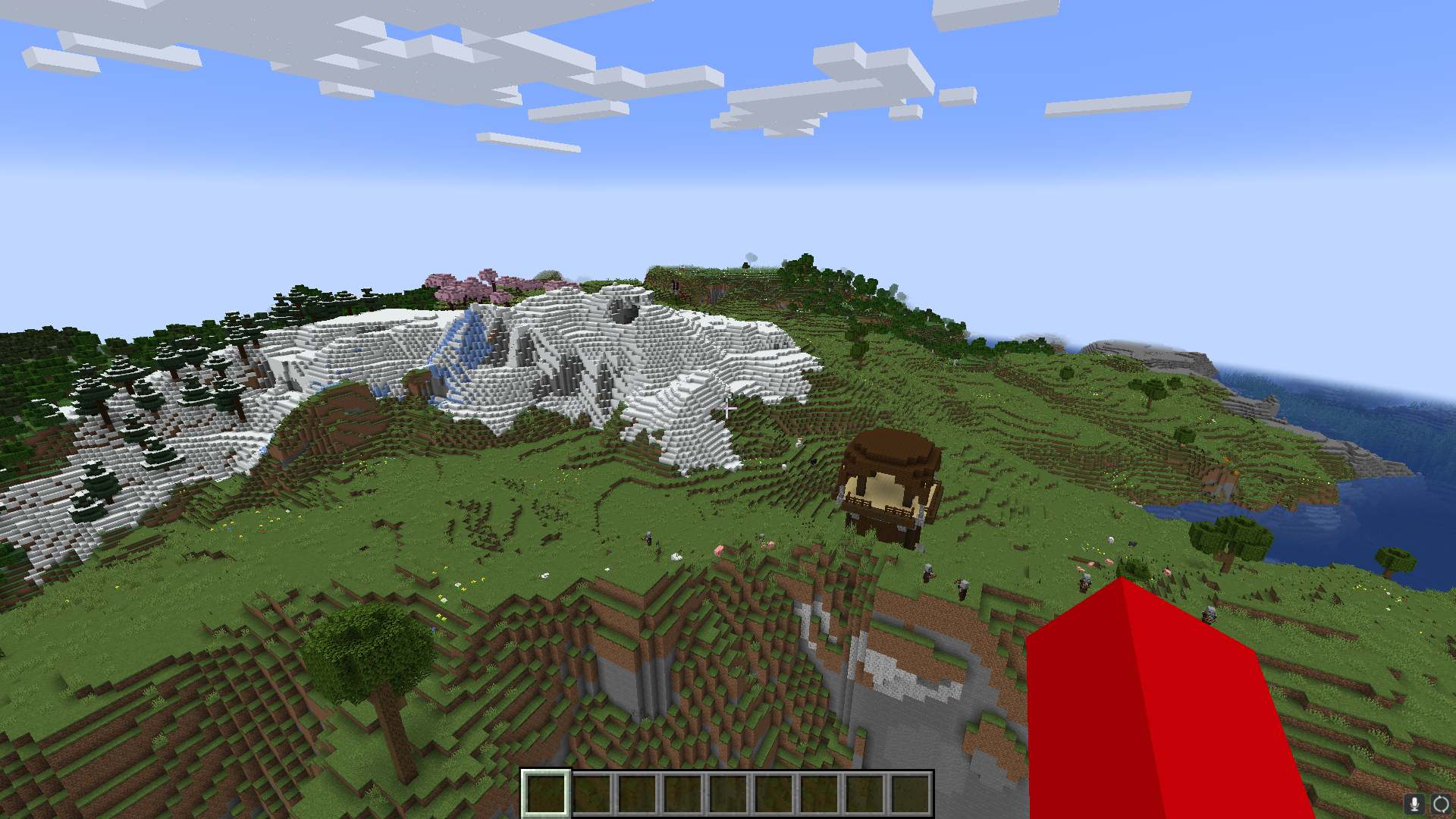 A Minecraft player floating in the air, looking at a Pillager Twoer, a snow biome, some pink Cherry Blossom trees, and a ruined portal. 