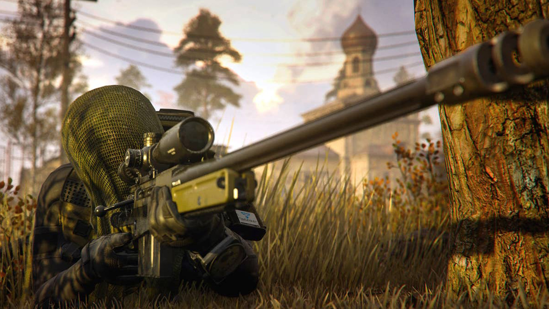 A Sniper wearing a Ghillie Suit lying down in the grass, aiming down a sniper scope.