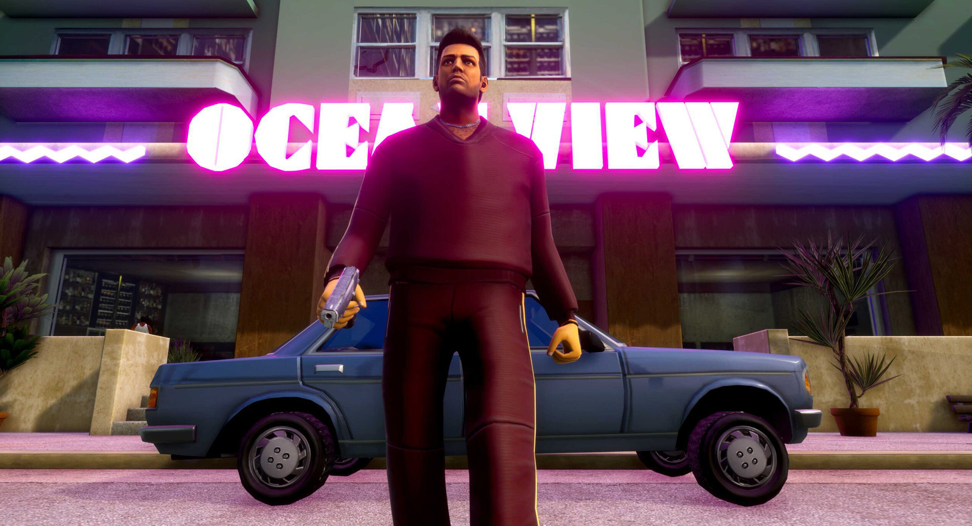 Tommy Vercitti, wearing red sweater and pants, carrying a pistol while walking away from a blue car.