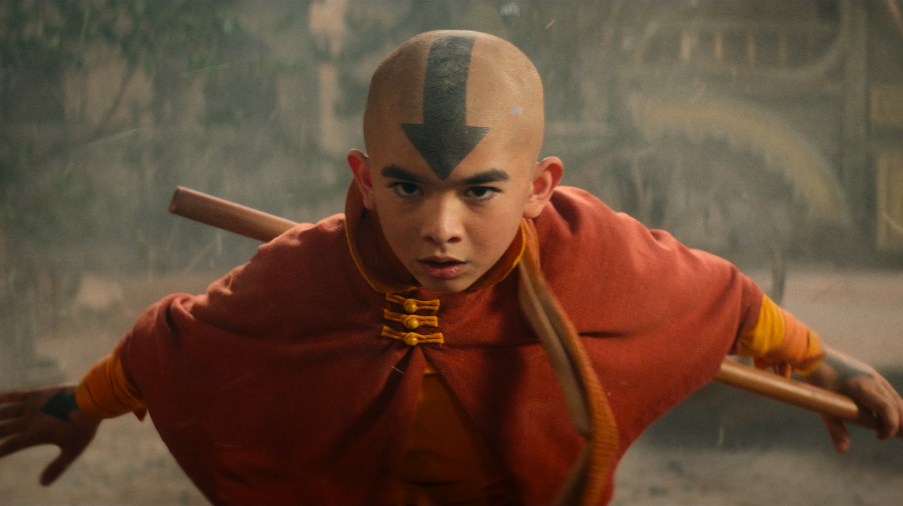 The live action Aang from Avatar: The Last Airbender, wearing orange robes and an arrow on his head