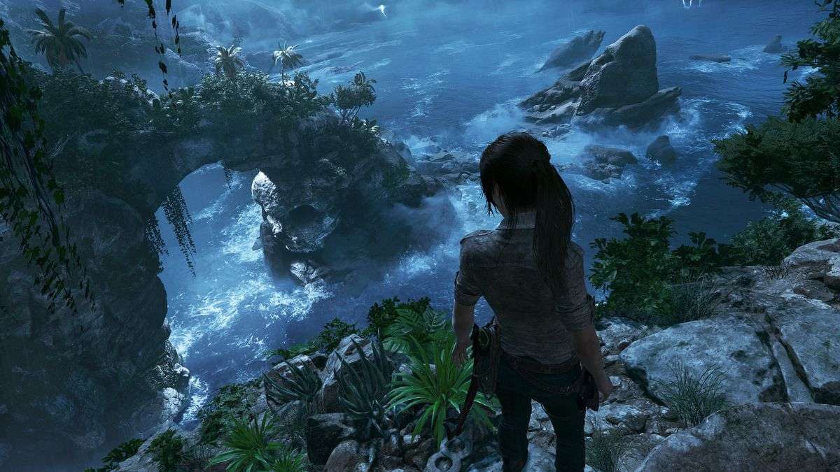 Lara Croft standing on a seaside cliff in Shadow of the Tomb Raider.