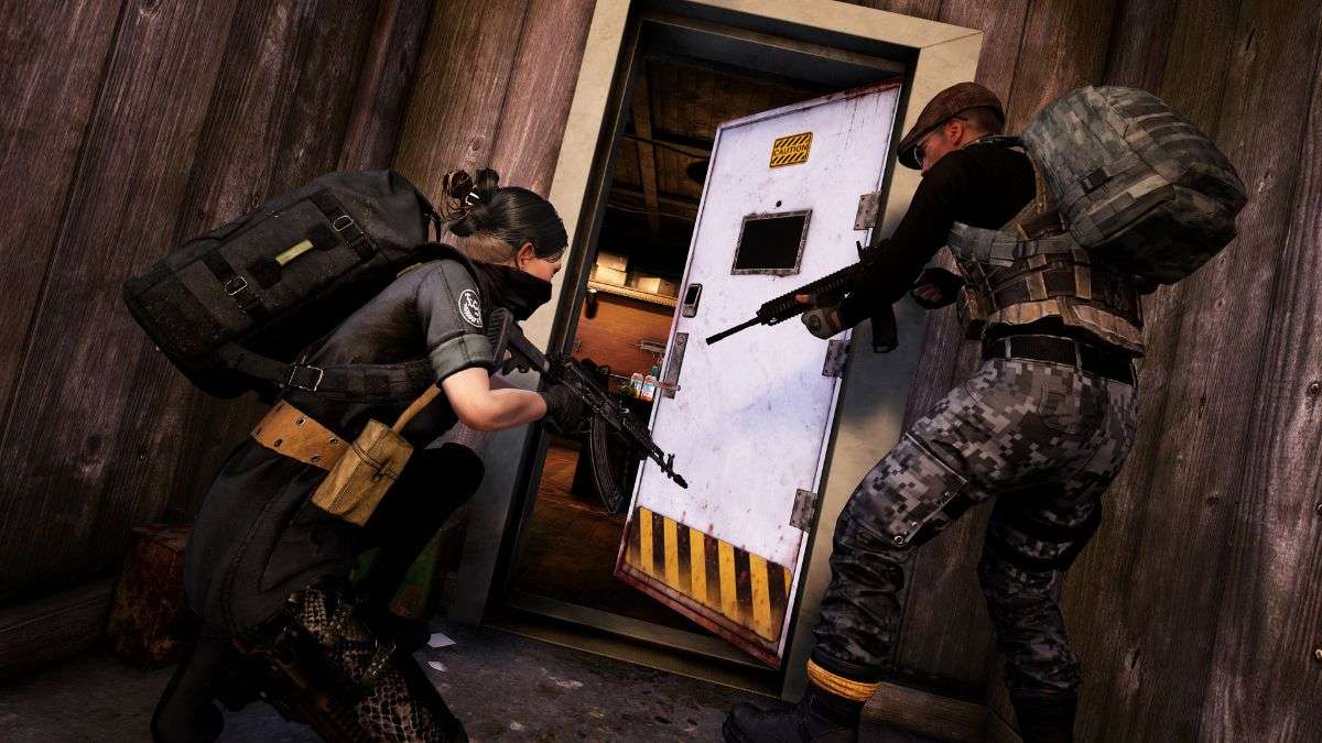 Two players prepare to breach a door in PUBG