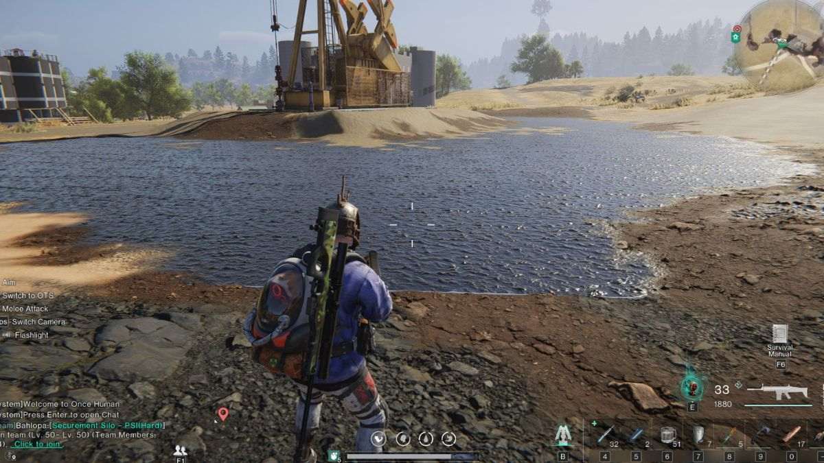 A player standing next to an oil field, showing that the ground is black and there's an oil drill in the background.
