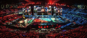 E-sportarena med tusenvis av tilskuere rundt scenen under en League of Legends-kamp